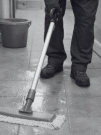 Treppenhausreinigung Eine Person wischt einen Boden mit einem Wischmopp in einem Innenraum.